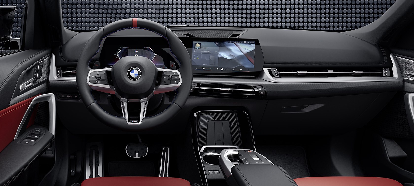 Interni della BMW X1 M35i xDrive con primo piano del volante e del display